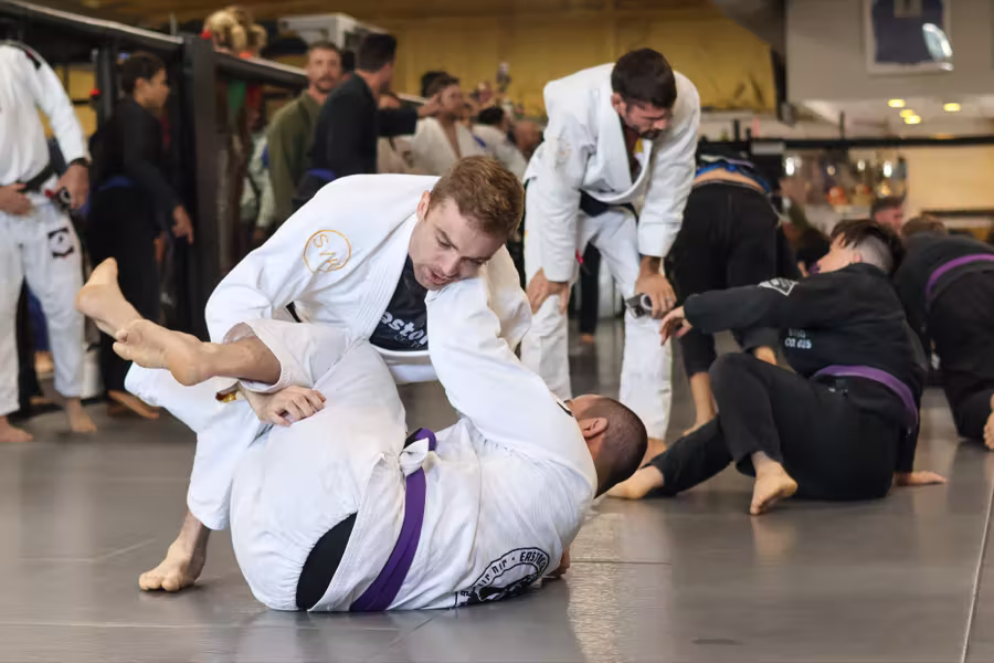 Purple belts rolling in a full gi class