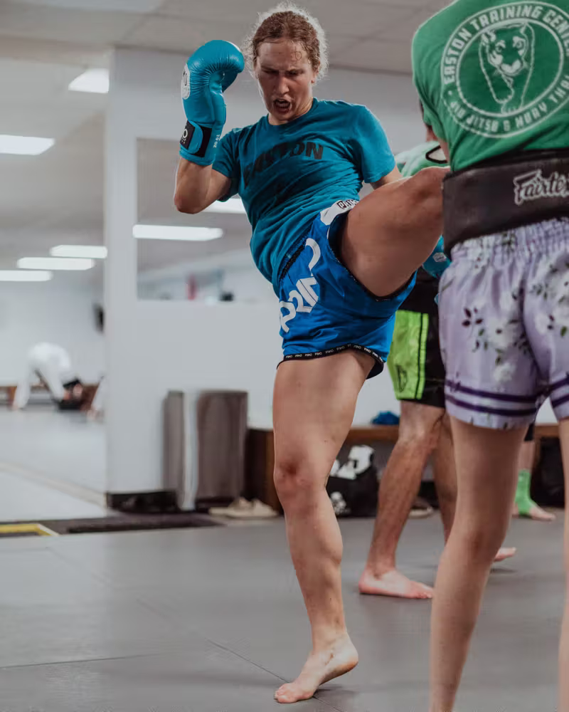 High kick on the pads in Muay Thai class at Easton Littleton