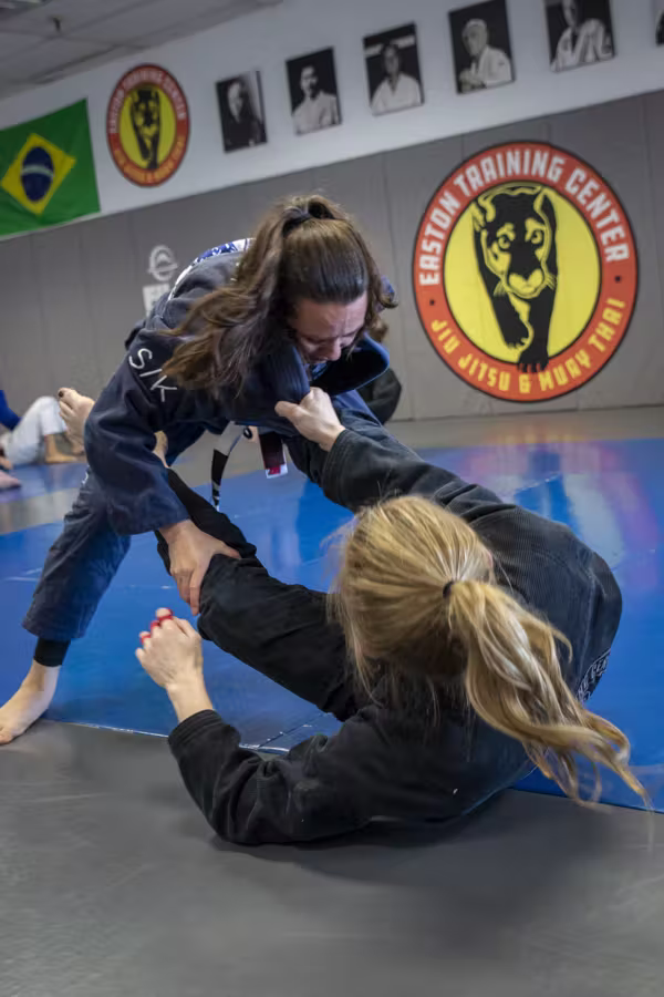 A woman passing her partner’s guard in gi jiu-jitsu at Easton