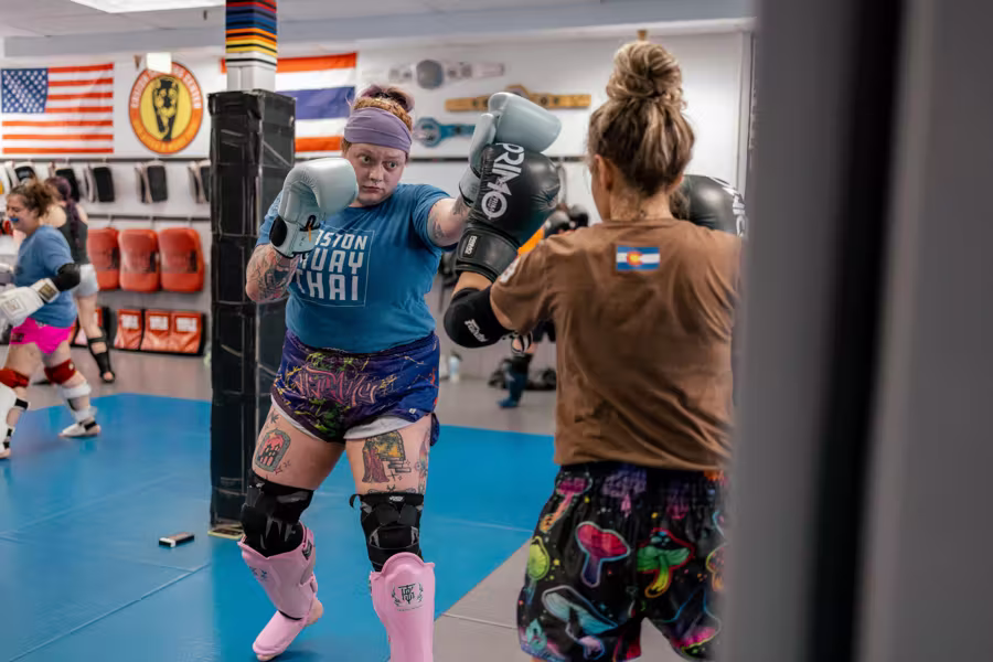 Two women trading punches in gloves in Easton’s women’s Muay Thai class