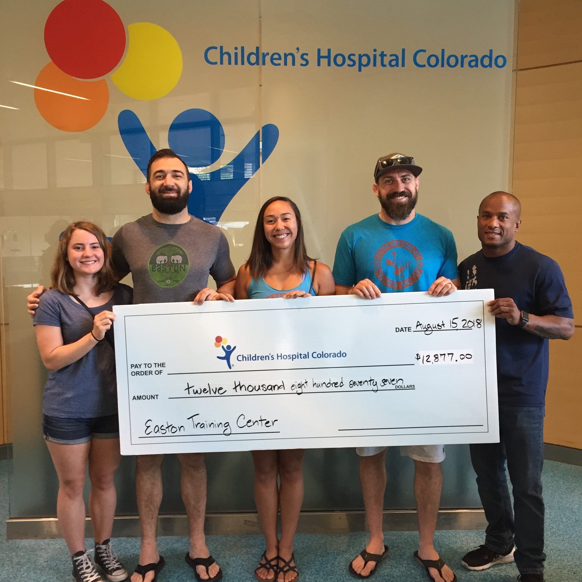 Easton Training Center staff present a donation check for $12,877 to Children's Hospital Colorado.