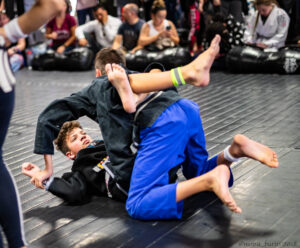 Two boys competing in the Easton in-house BJJ tournament. One has the other in closed guard.