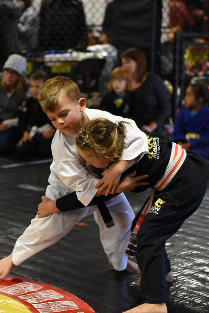 A boy and a girl try to take each other down in martial arts for kids at Easton