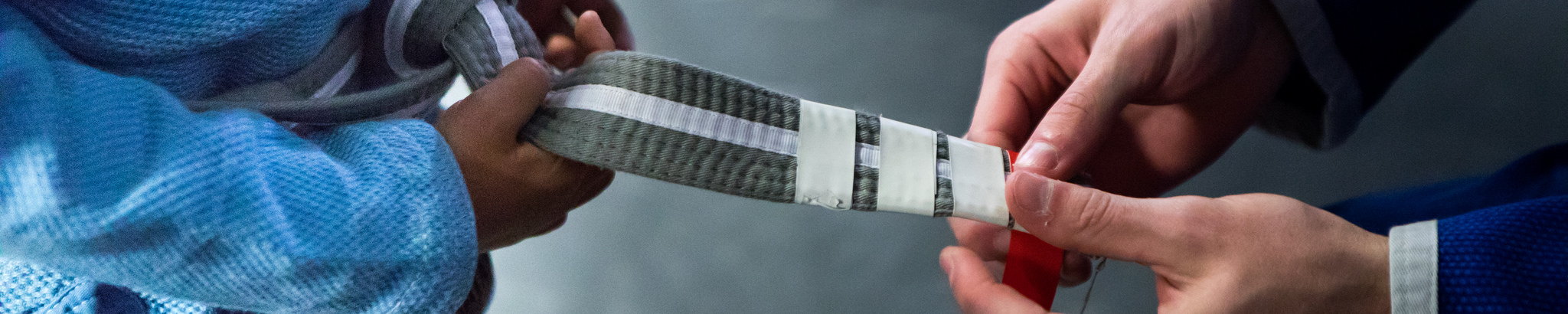 A student receives a stripe on their BJJ belt