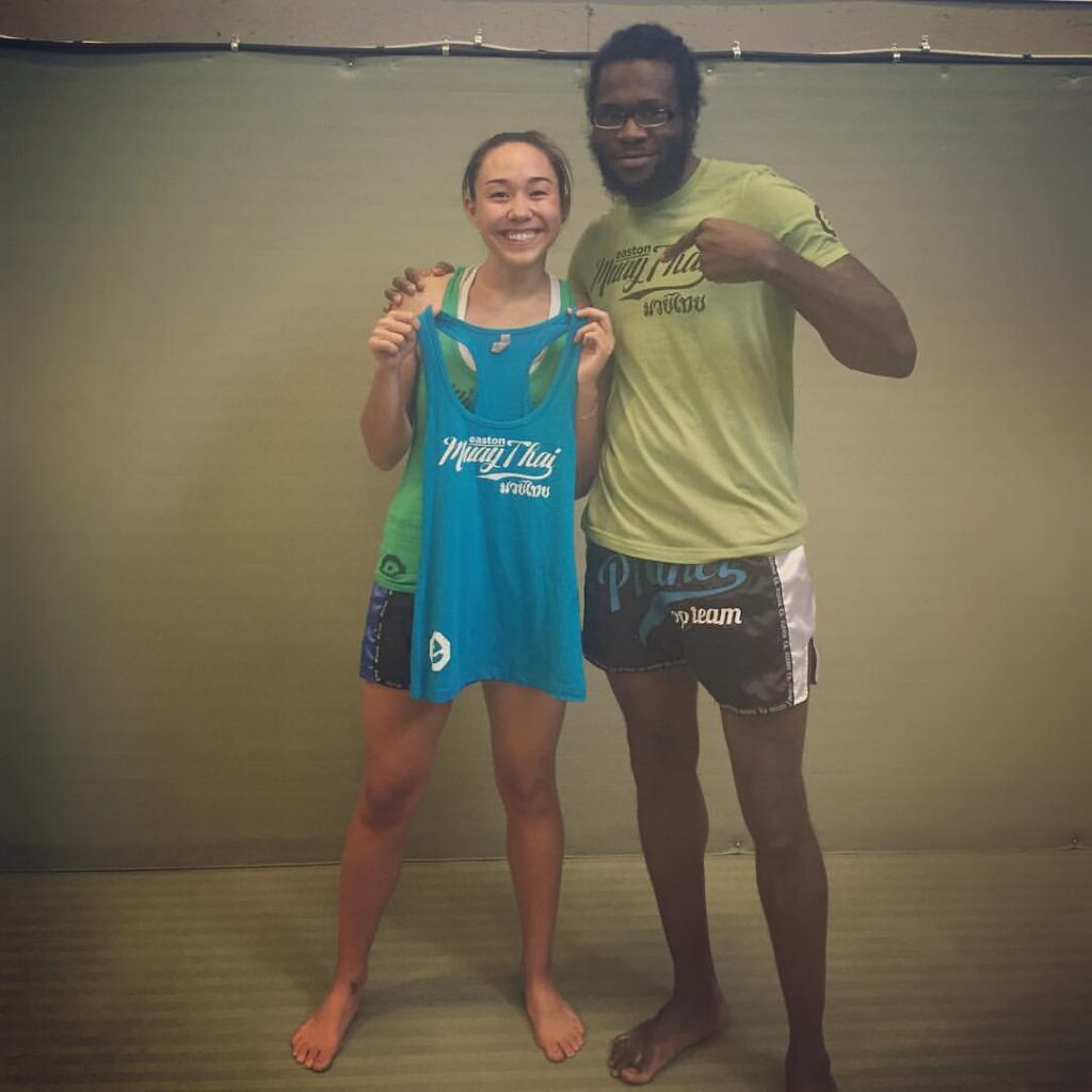 Sachi Ainge receives her blue shirt promotion from Easton Muay Thai coach Terrence Moore
