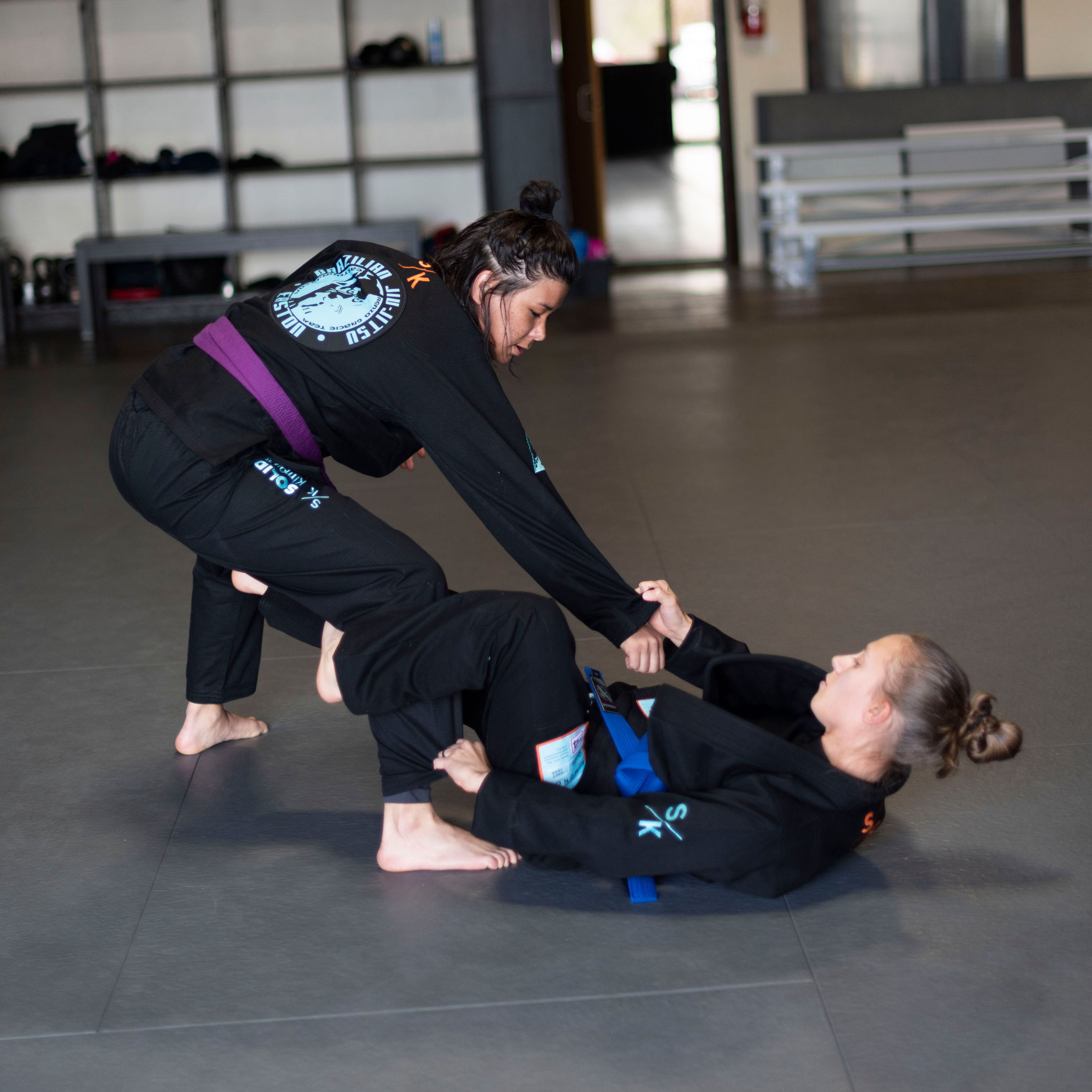 An image of two women training Brazilian Jiu-Jitsu at Easton Training Center, a Martial Arts academy in Denver, Colorado.