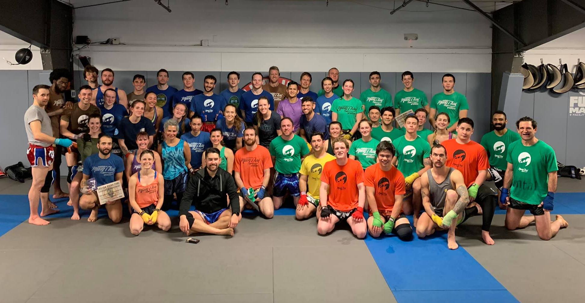 a large group of Easton Muay Thai students wearing their colored ranked shirts