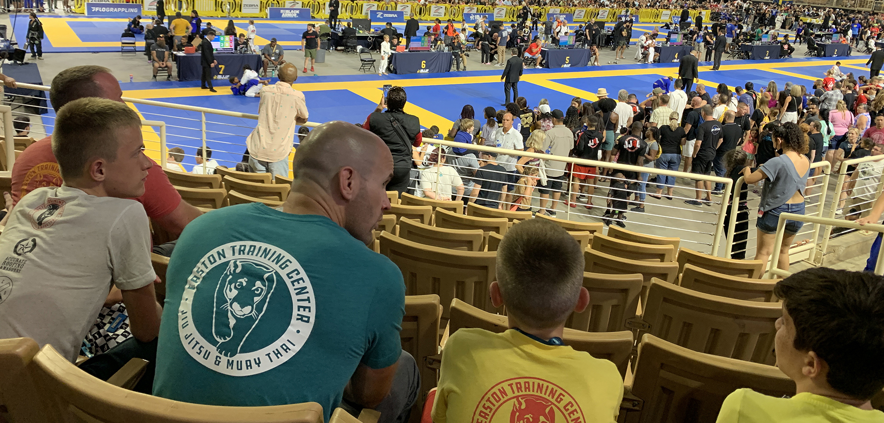 An image of a Coach and his student at a Youth Brazilian Jiu-Jitsu competition.