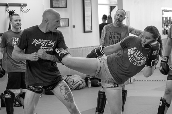 An image of a Muay Thai class at Easton Training Center in Centennial, which shows a student demonstrating a kick technique