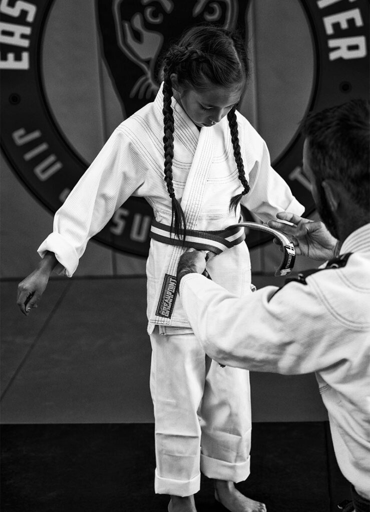 An image of a girl getting her new Brazilian Jiu Jitsu belt.