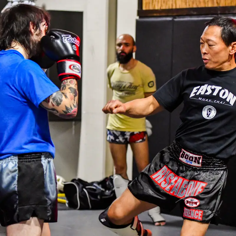 A Muay Thai instructor at Easton Training Center in Arvada, CO teaching a roundhouse kick during a training session.