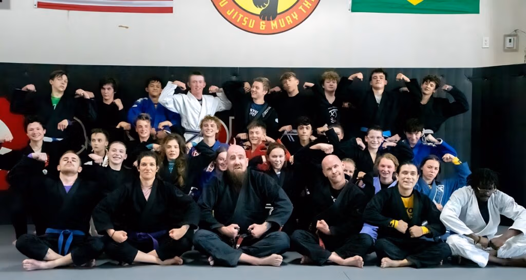 A group of kids and teenagers taking a group photo after a kids jiu jitsu training session in Denver, Colorado.