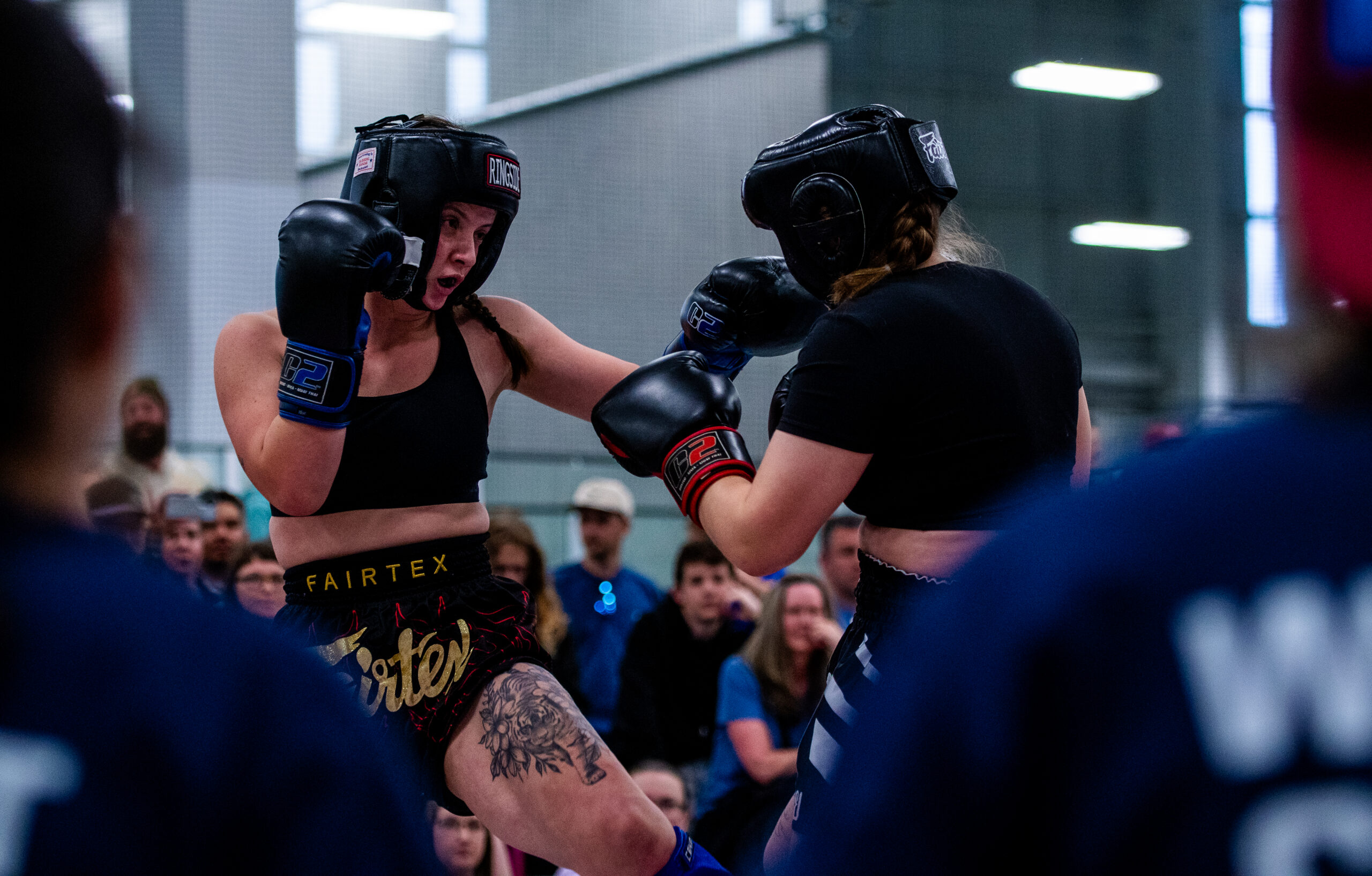 two women in headgear and boxing gloves Competing in Muay Thai