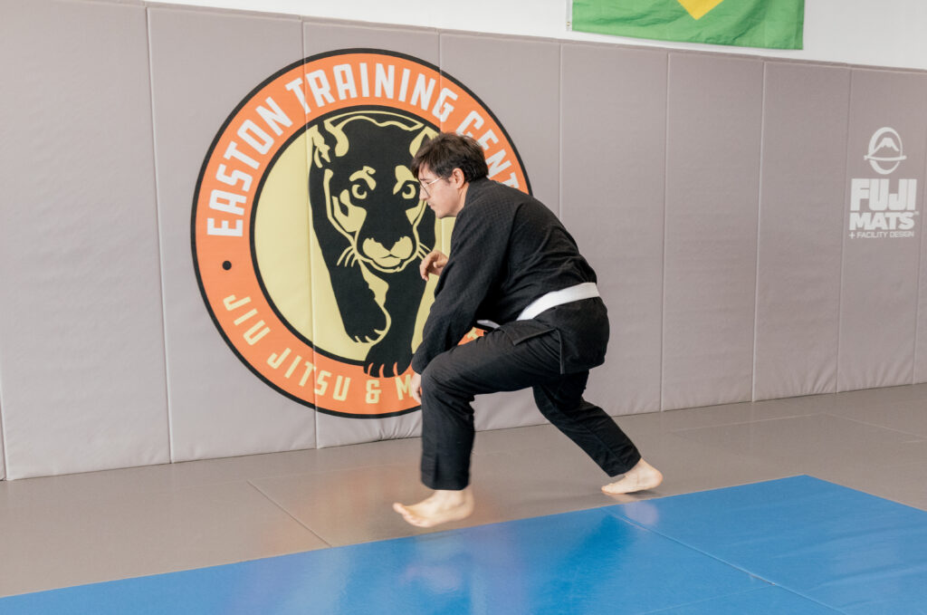A man in a black gi with a white belt practices changing level