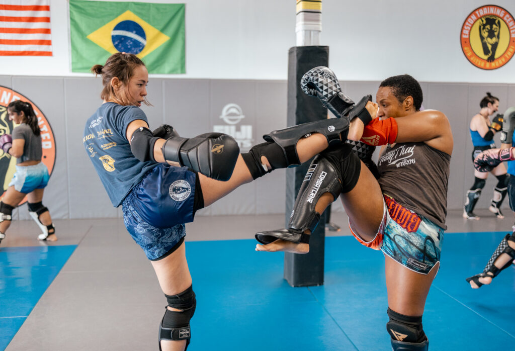 two women demonstrate types of sparring in muay thai